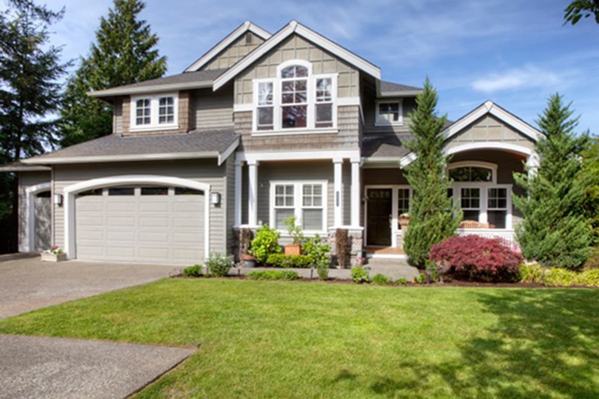 House plan exterior. Two-story home with Craftsman-style elements. Features include a front porch with columns, gables, and an attached garage.