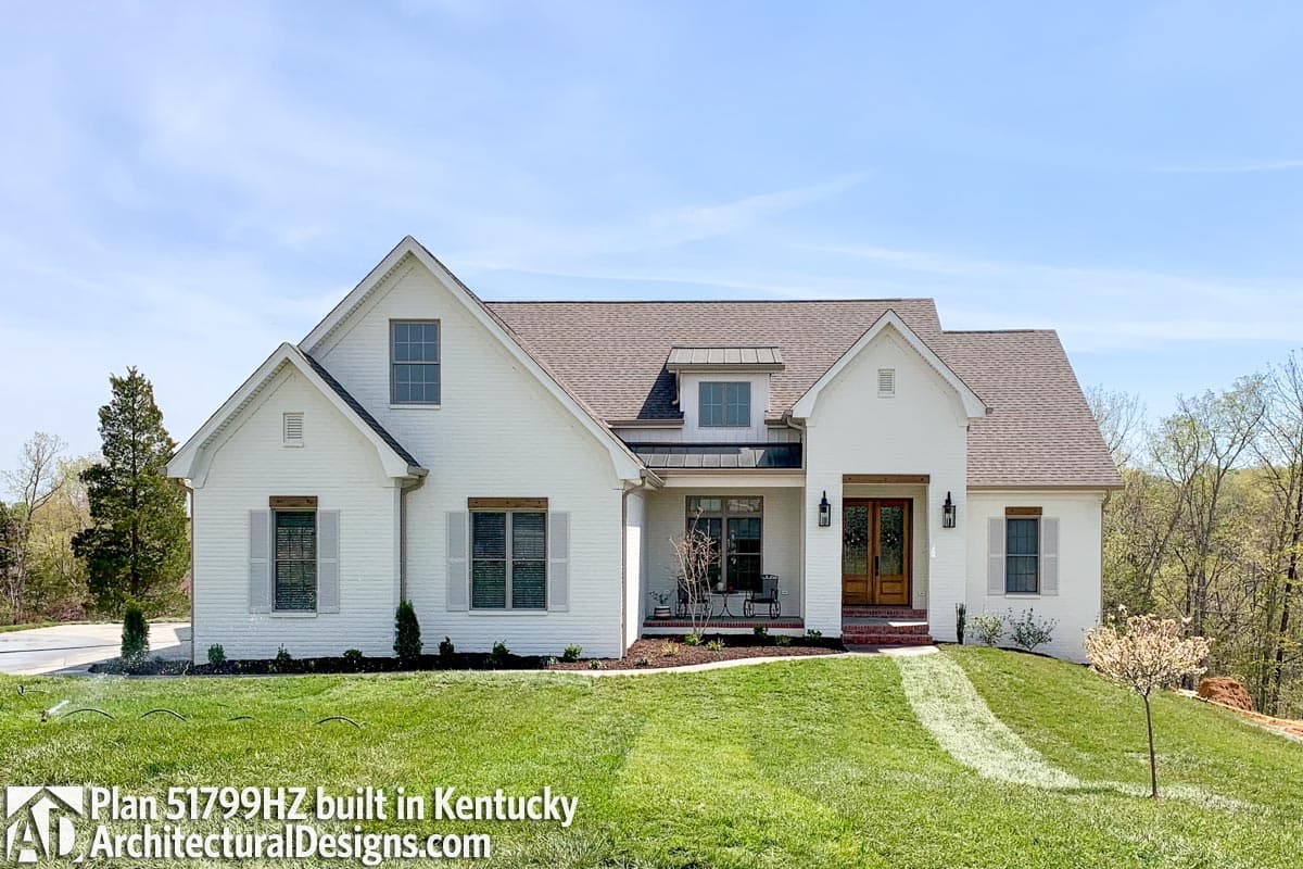 House plan exterior: Two-story Modern Farmhouse with brick facade, gabled roof, dormer, and covered front porch.