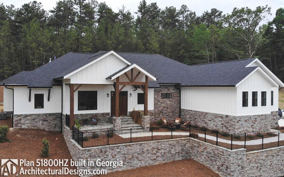 House plan exterior: One-story modern farmhouse with stone and board-and-batten siding, exposed rafter entry, and prominent gables.