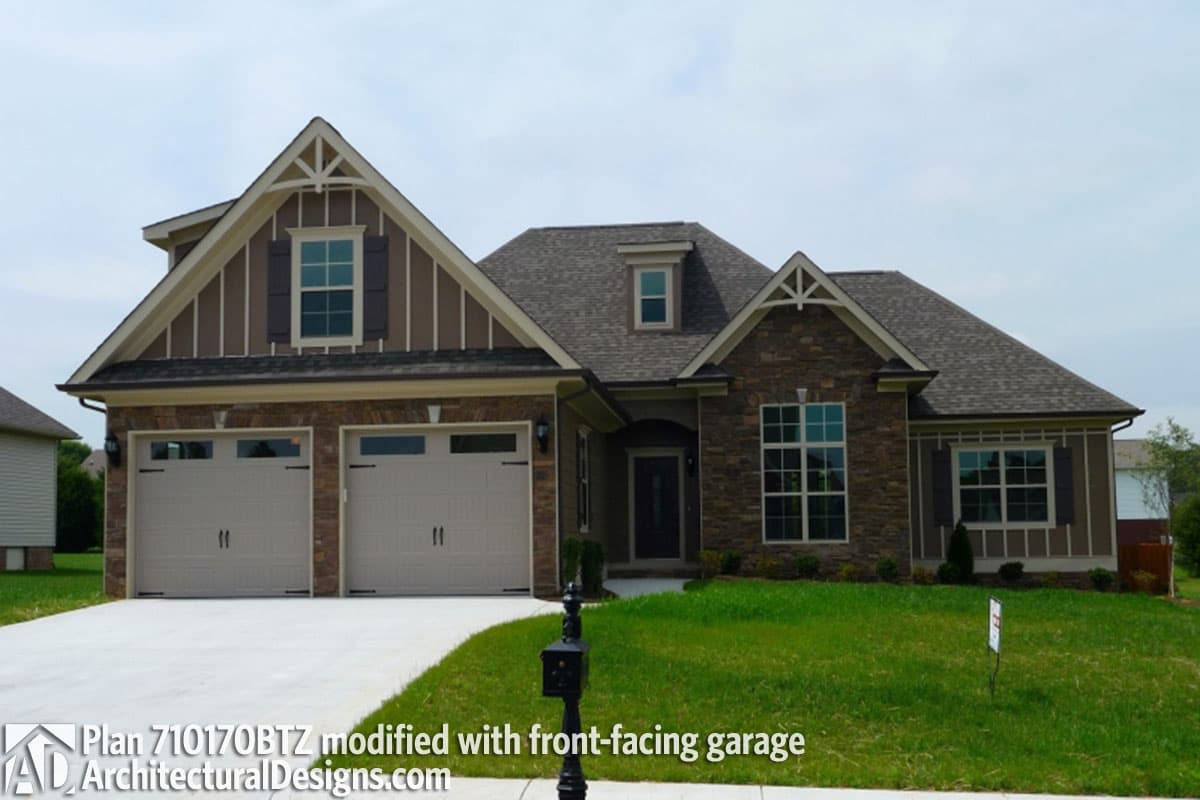 House plan exterior with stone and vertical siding, dormer, and a front-facing three-car garage.