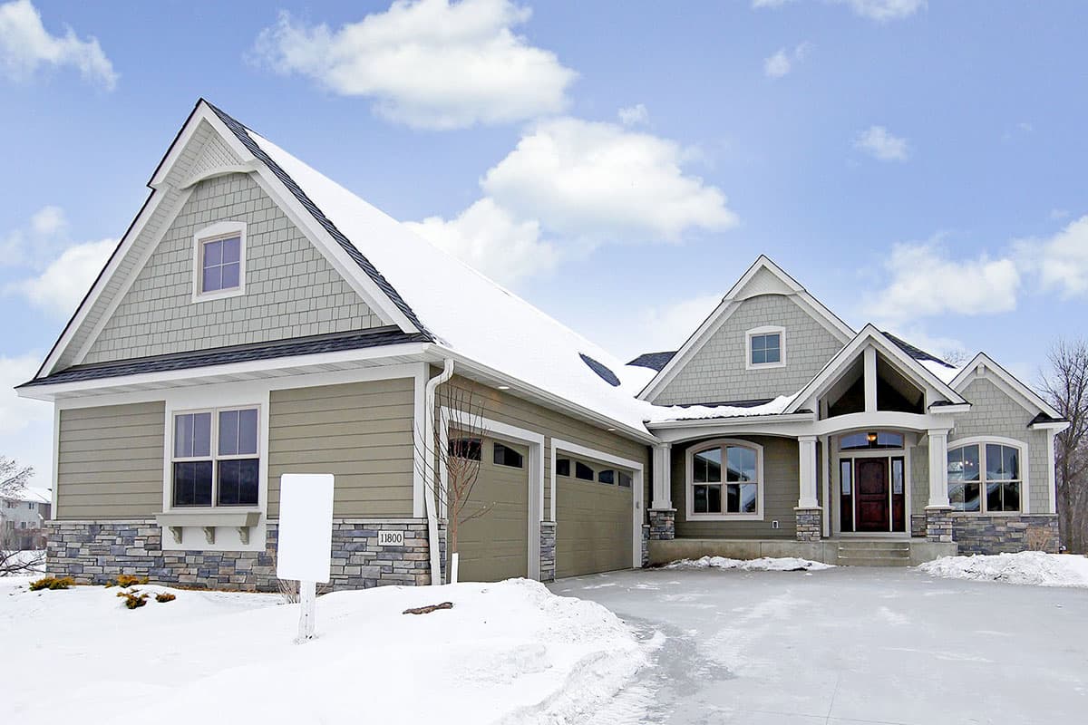 House plan exterior. Two-story with Craftsman style, featuring gabled rooflines, stone facade, and a front entry porch.