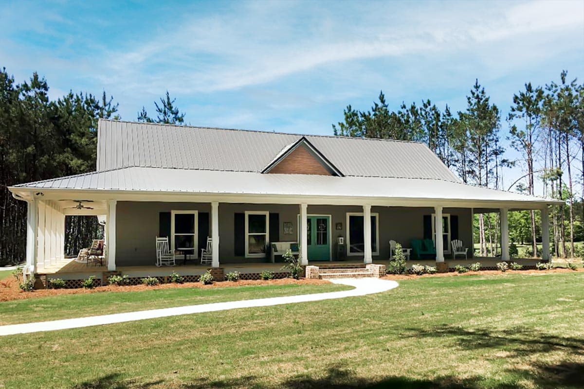 Modern farmhouse plan exterior with wraparound porch, metal roof, and central gable.