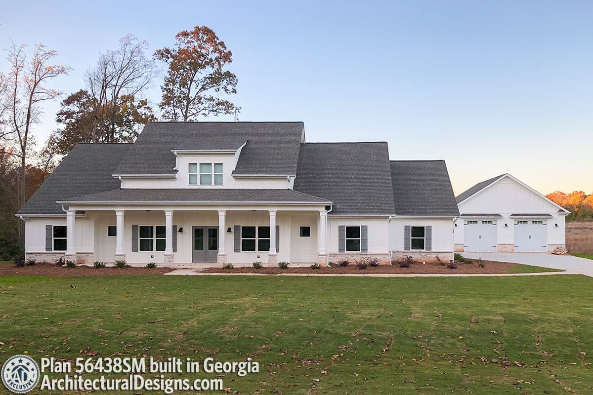 House plan exterior: Modern Farmhouse style, one-story with prominent covered porch, gables, dormer, and attached three-car garage.