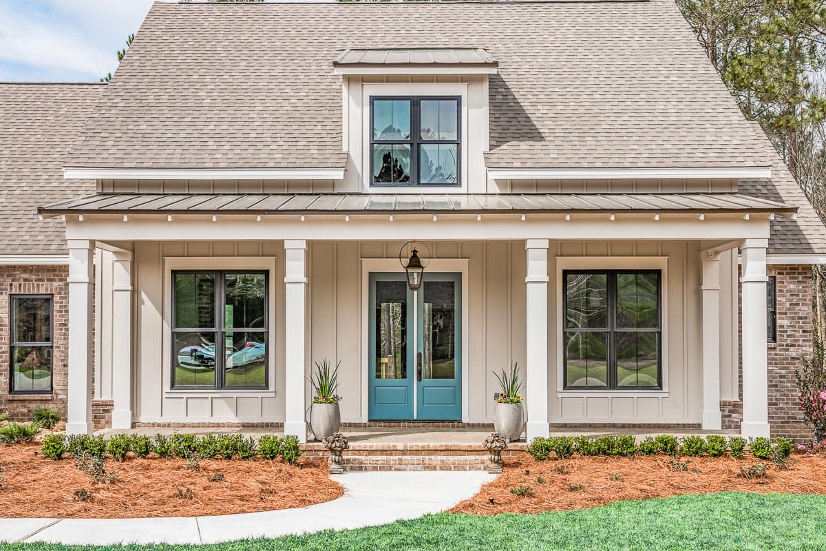 House plan exterior: Modern Farmhouse style with a covered front porch, dormer window, and brick accents.