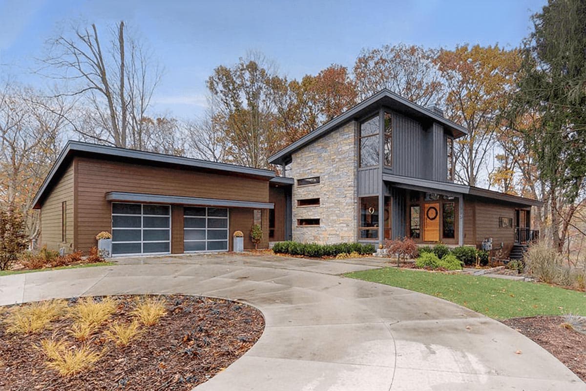 House plan exterior with two stories, a contemporary style with stone and wood siding, and a gabled roof. Includes a two-car garage.