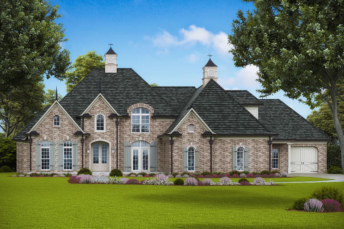 House plan exterior. Two-story brick home with gabled roof, dormers, and front-facing garage. Features include arched windows and decorative cupolas.