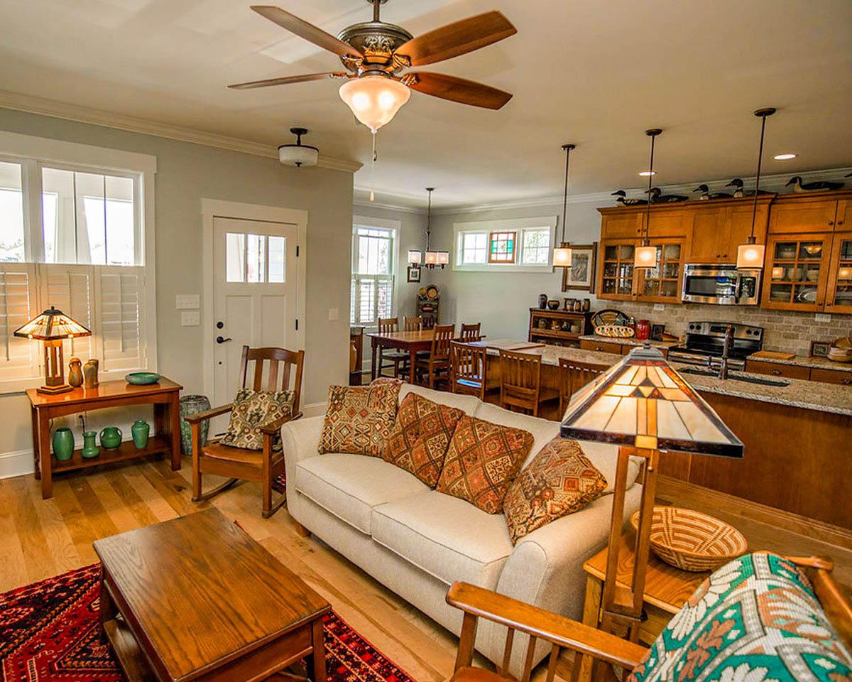 Open-concept living area with a sofa, dining table, wood cabinets, and kitchen island.