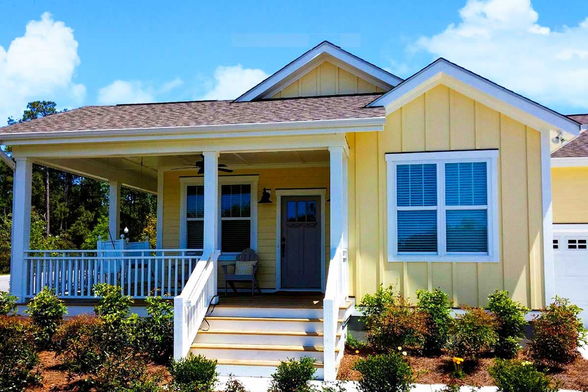 House plan exterior with Craftsman style. Features a front porch, gables, and a prominent roofline. One-story home with a garage visible on the right.