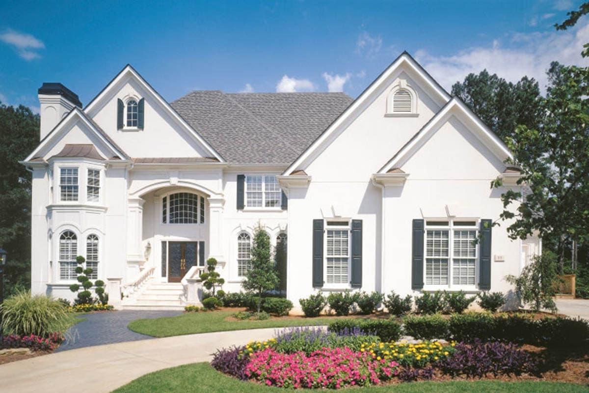 Two-story house plan exterior with arched entryway, bay window, multiple gables, and dormer.