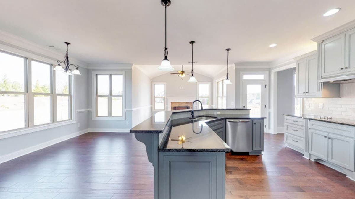 Kitchen with island, granite countertops, stainless steel appliances, and open-concept dining area with large windows.