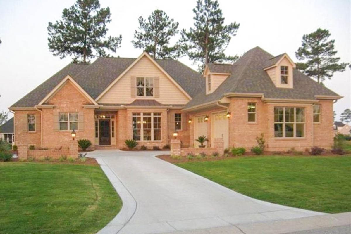House plan exterior with brick facade, two stories, gabled roof, dormers, and attached garage with two bays and a driveway.