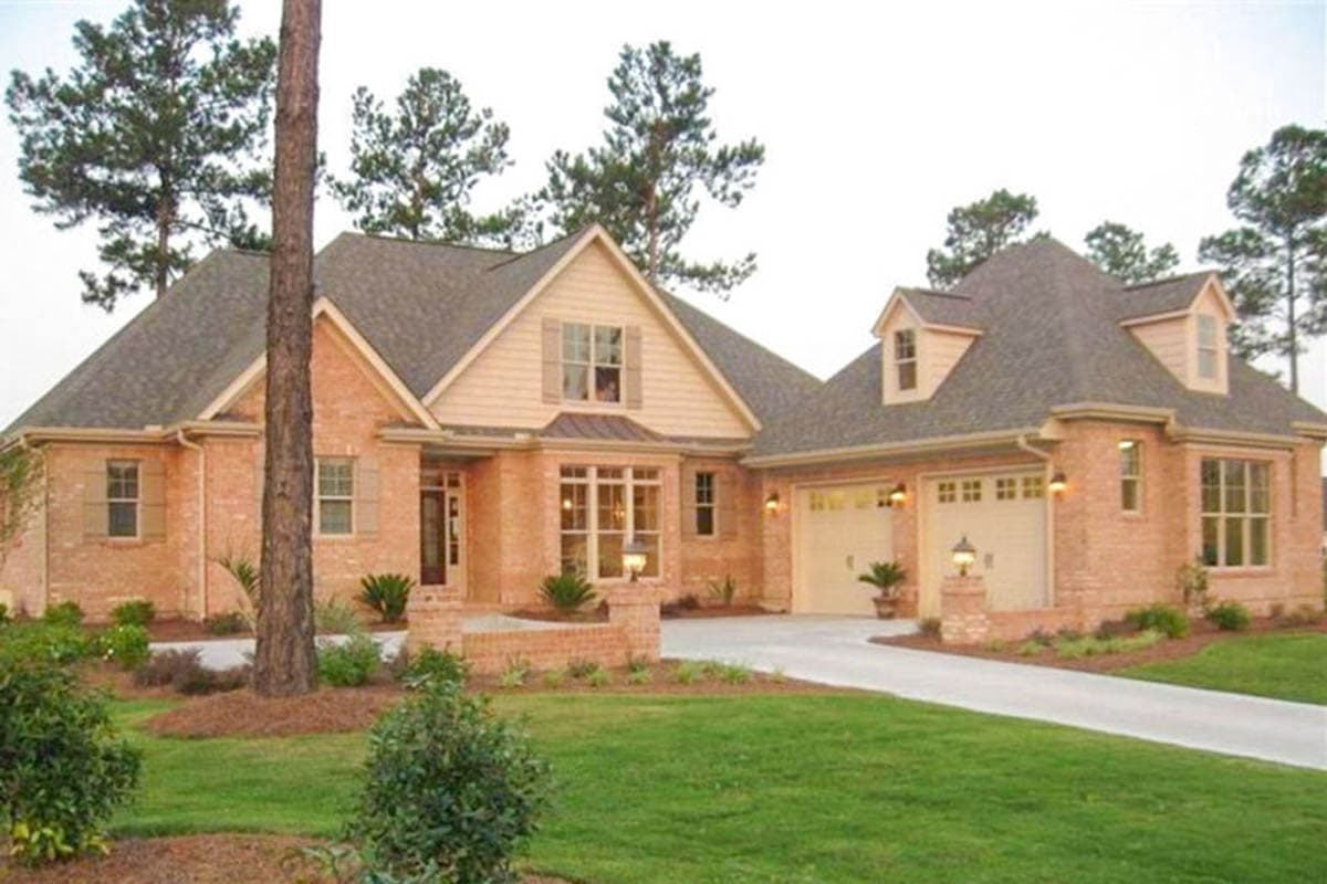 House plan exterior: Brick ranch with dormers, a gable over the entrance, and a side-facing three-car garage.