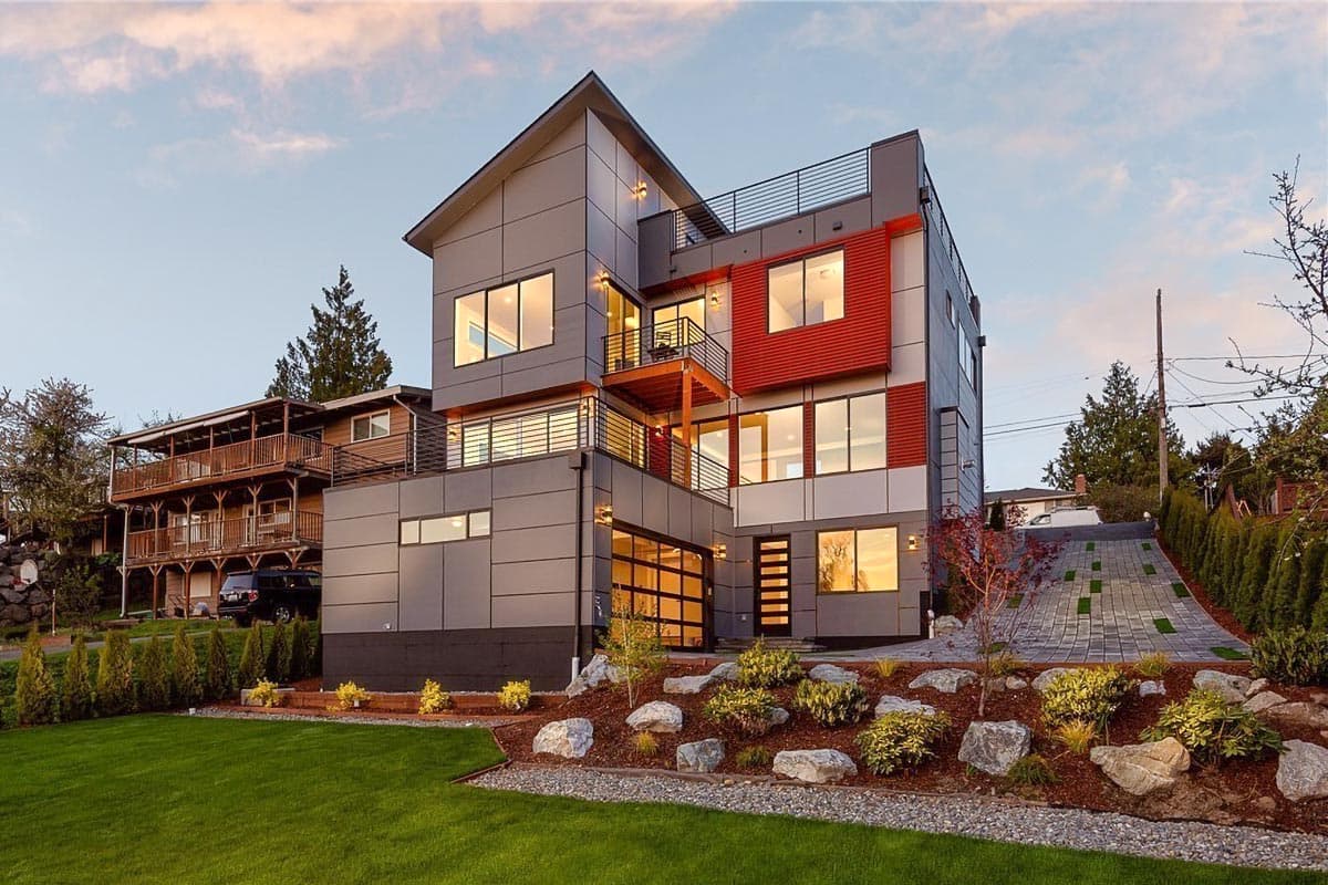 House plan exterior. Modern, multi-story home with a flat roof, balcony, and garage door. Features include large windows and red accents.