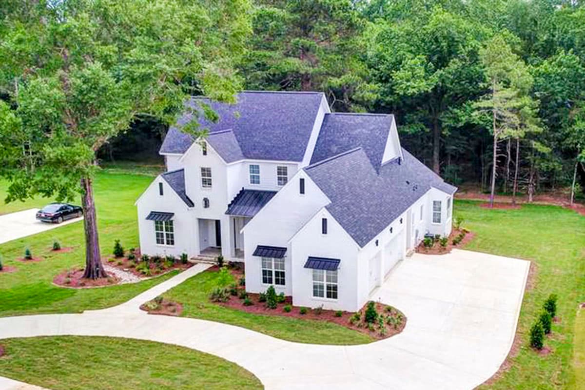 House plan exterior: two-story Modern Farmhouse with white siding, dark roof, multiple gables, and a three-car garage.