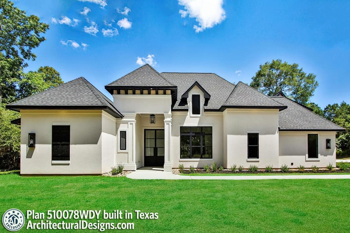 House plan exterior: Modern style, one story, with a covered entry, gables, dormer, and large windows.