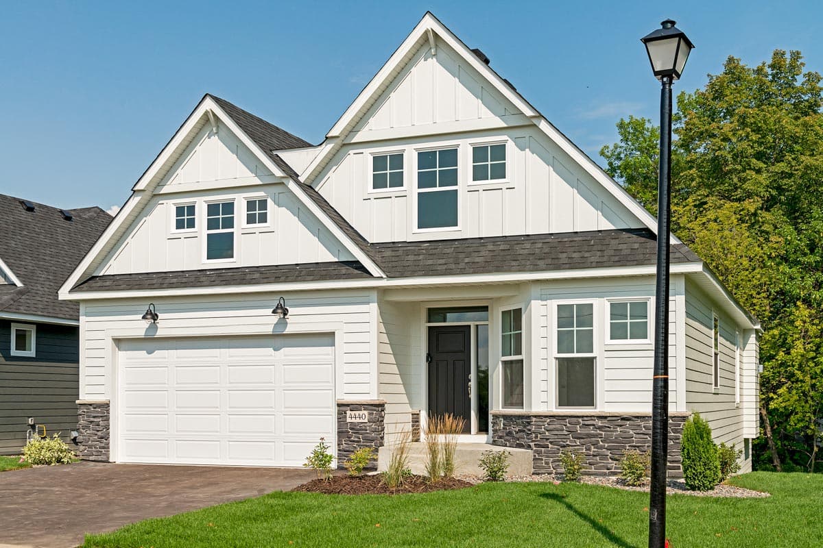 Modern Farmhouse house plan exterior, two stories, with a prominent gable, attached garage, and stone foundation.