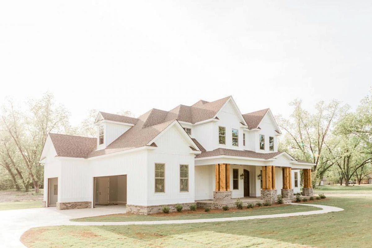 Modern Farmhouse house plan exterior, two stories, gabled rooflines, wide front porch with wood columns, and attached three-car garage.