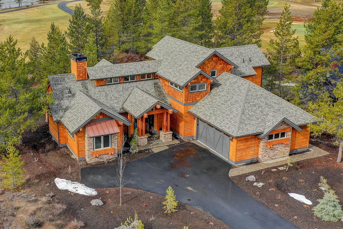 House plan exterior of a two-story Modern Mountain home with a prominent gable, stone accents, and a detached garage.