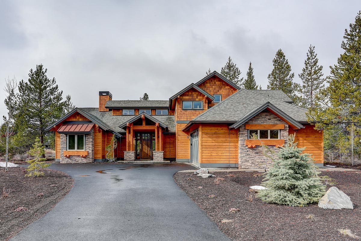 Craftsman style house plan exterior with wood siding, stone accents, covered entry, and multiple gables.