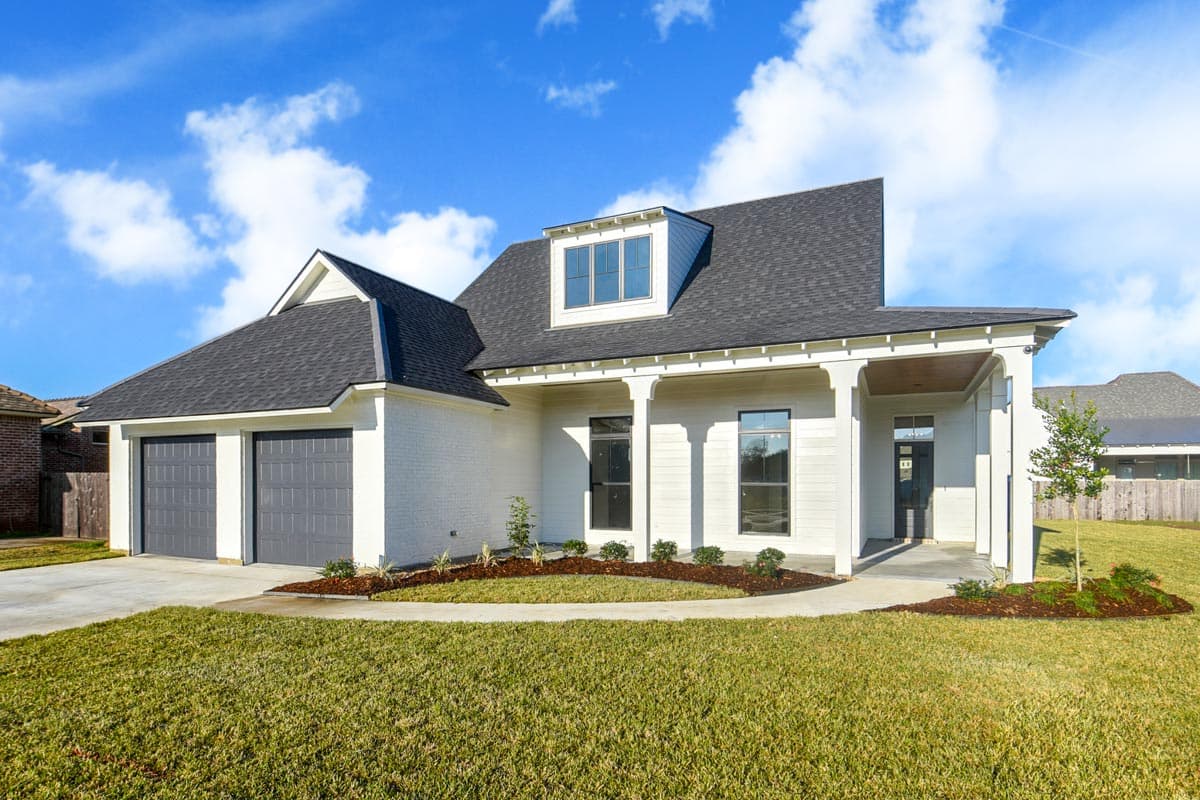 House plan exterior. One-story Craftsman home with a gabled roof, dormer window, covered porch, and a two-car garage.