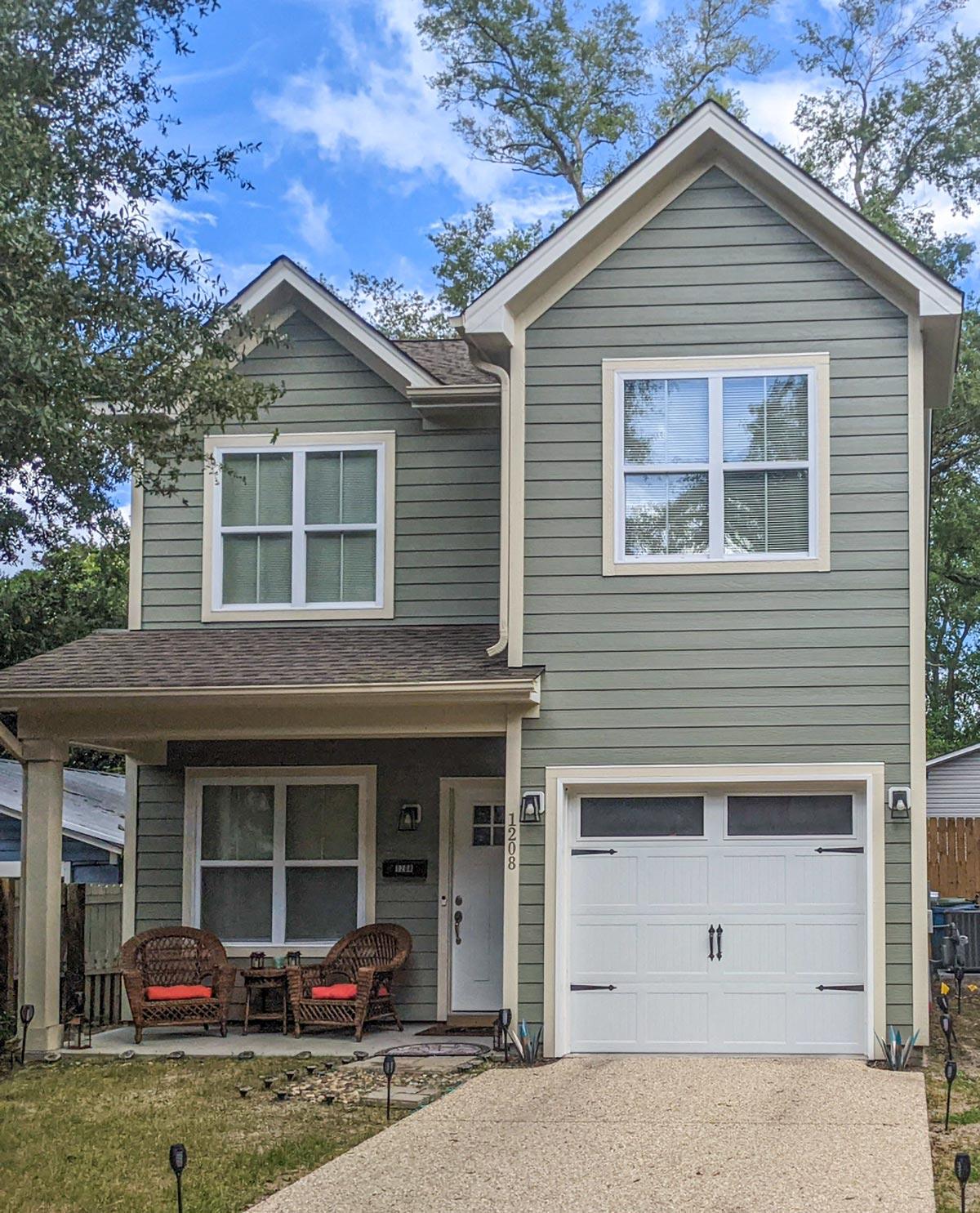Two-story house plan exterior with gabled rooflines, covered front porch, and a side-facing garage.