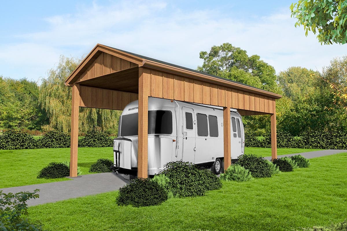 A-frame carport structure with wood siding. Airstream trailer parked beneath. Features include an asphalt driveway and surrounding landscaping.
