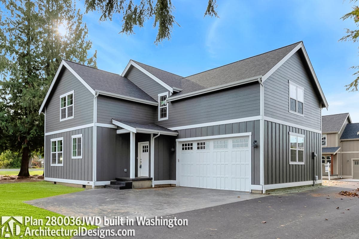 House plan exterior: Two-story Modern Farmhouse with white-trimmed windows, covered entry, and side-facing garage.