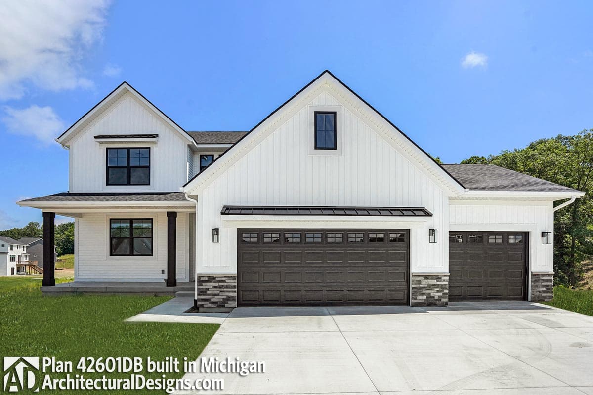 House plan exterior: two-story Modern Farmhouse with board and batten siding, gable roof, dark garage doors, and stone accents.