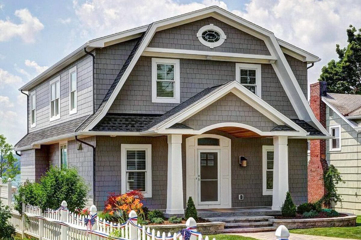 House plan exterior with two stories and a Dutch gambrel roof. Features include a front porch, multiple dormers, and a gable over the entry.