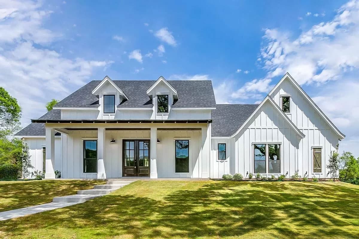 House plan exterior. Modern Farmhouse style with two stories, gabled rooflines, dormers, and a covered front porch with columns.