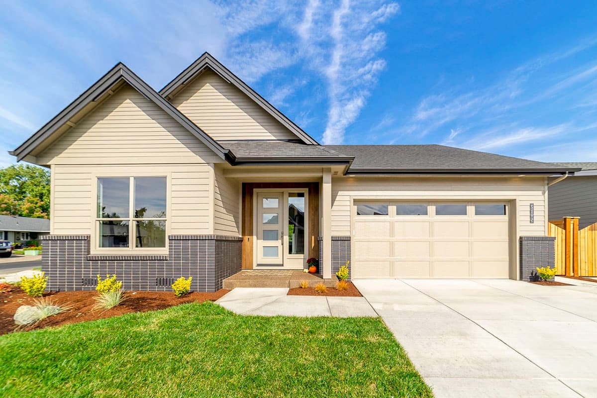 House plan exterior featuring a single story, gable roof, and attached garage. Exterior includes brick accents, and a covered front entry.