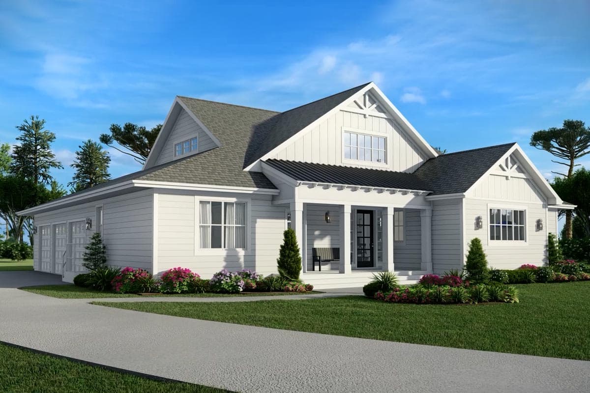 A white, two-story house with a grey roof and black door, featuring a landscaped yard and a concrete driveway leading to the garage.