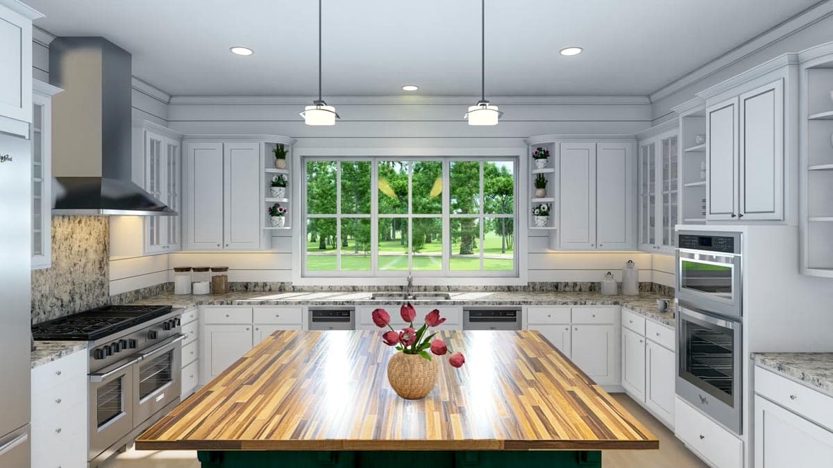 Bright, modern kitchen featuring white cabinets, stainless steel appliances, and a large wooden island with a vase of red tulips.