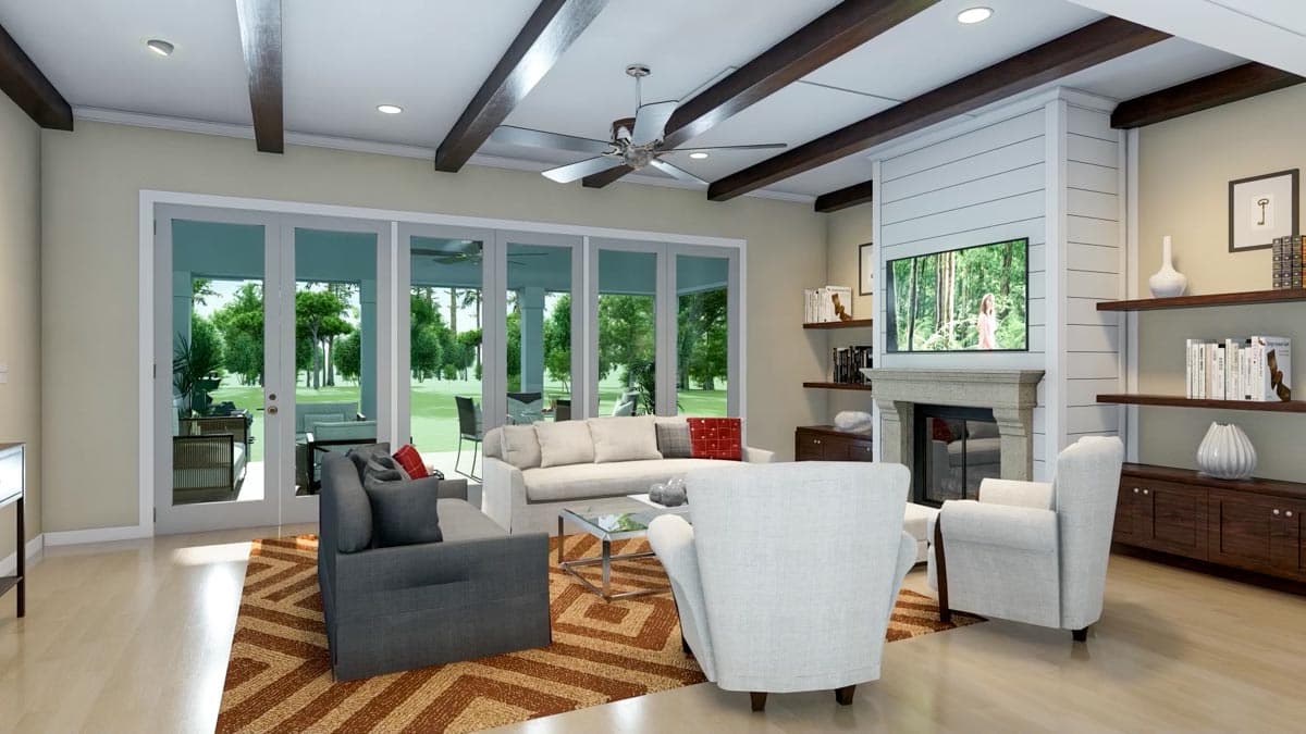 A modern living room with large windows overlooking a patio. The room features a fireplace, comfortable seating, and a patterned rug.
