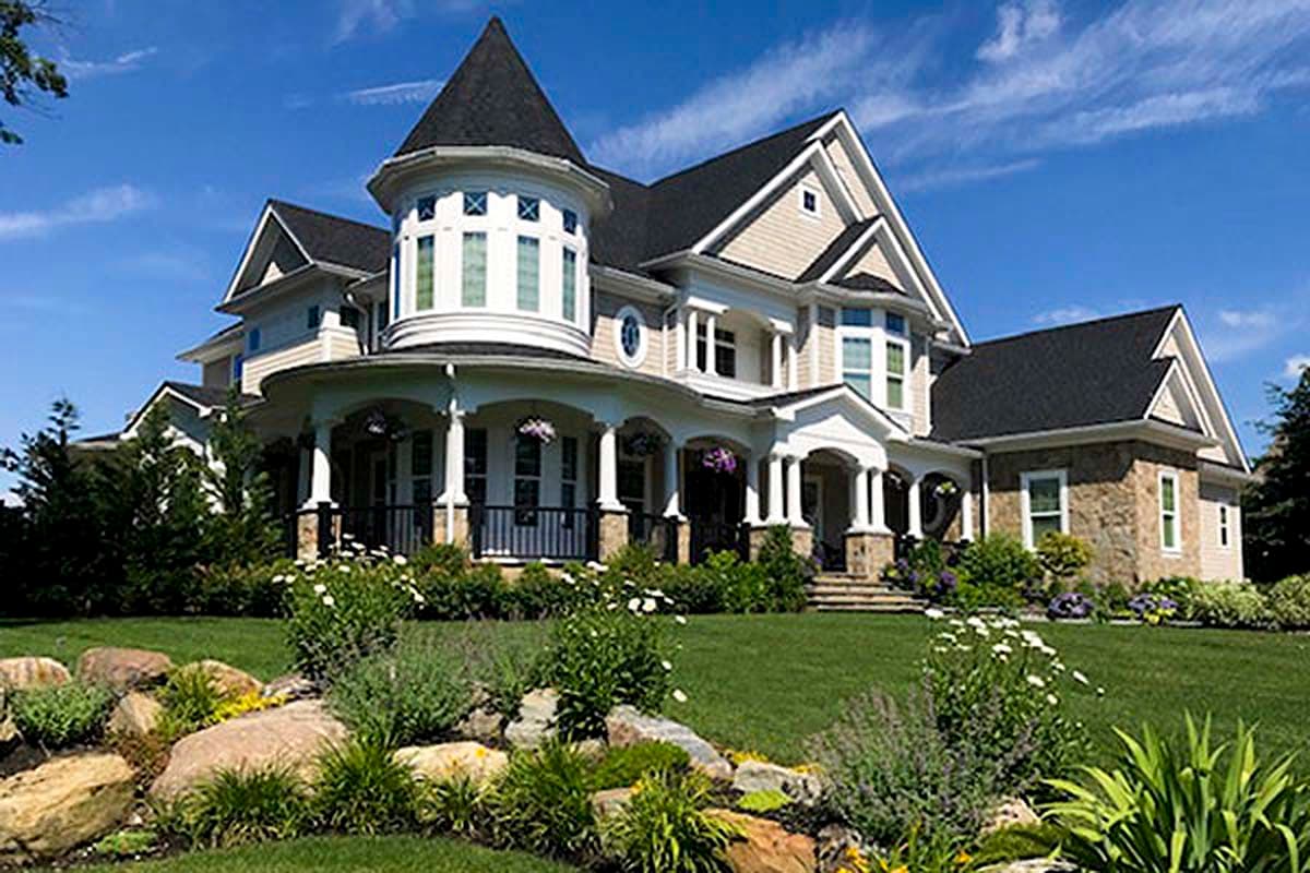 House plan exterior of a multi-story home with a prominent turret, wrap-around porch, gables, and stone accents.
