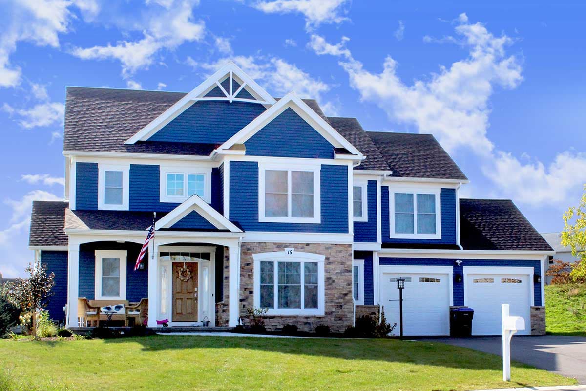 House plan exterior. Two-story home with blue siding, front porch, multiple gables, and attached garage with two bays.