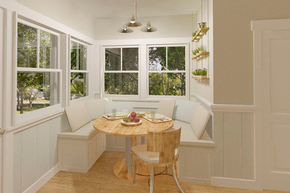 Breakfast nook with built-in seating, round table, and large windows overlooking trees. Pendant light fixture hangs above.