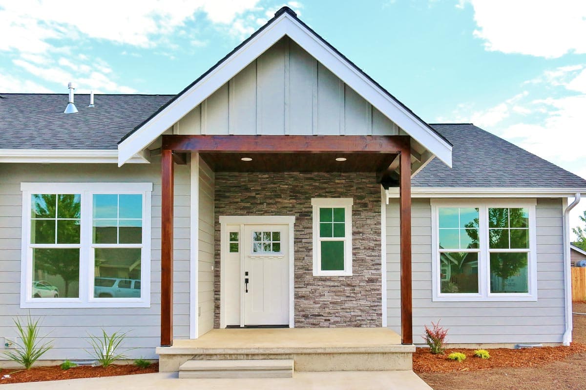 House plan exterior: One-story home with covered porch, stone accent wall, and gabled roofline.