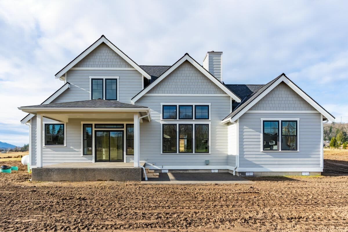 Modern Farmhouse style house plan exterior with covered porch, multiple gables, and large windows.