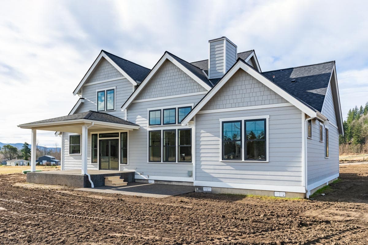 House plan exterior: Two-story Modern Farmhouse with gabled rooflines, shingle accents, covered front porch, and prominent chimney.