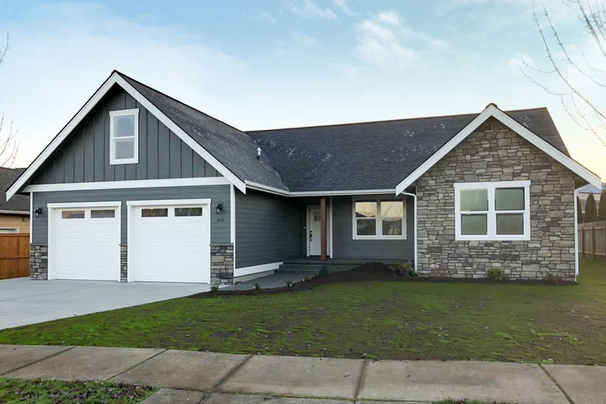 House plan exterior featuring a two-car garage, stone veneer accent, and a front gable. It has a neutral color palette.