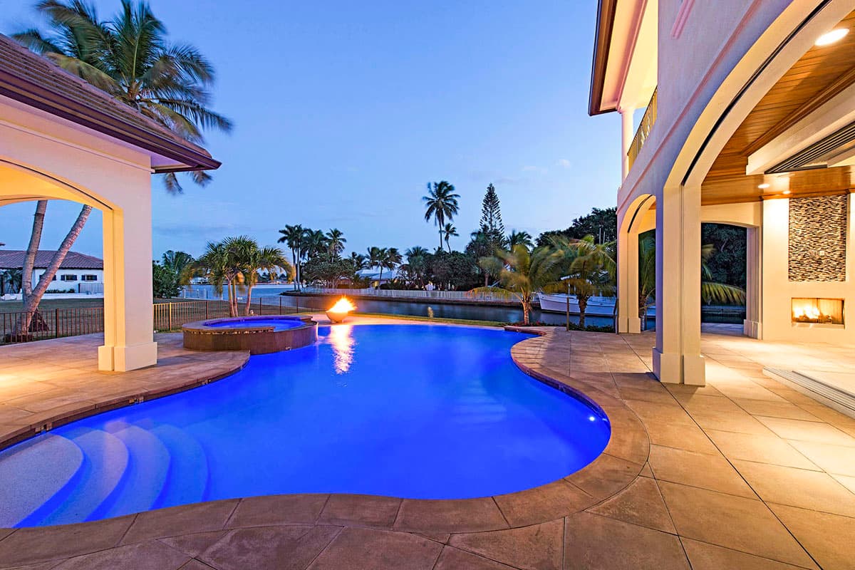 House plan exterior: Modern two-story home with covered patios, arched entrances, and prominent gables.