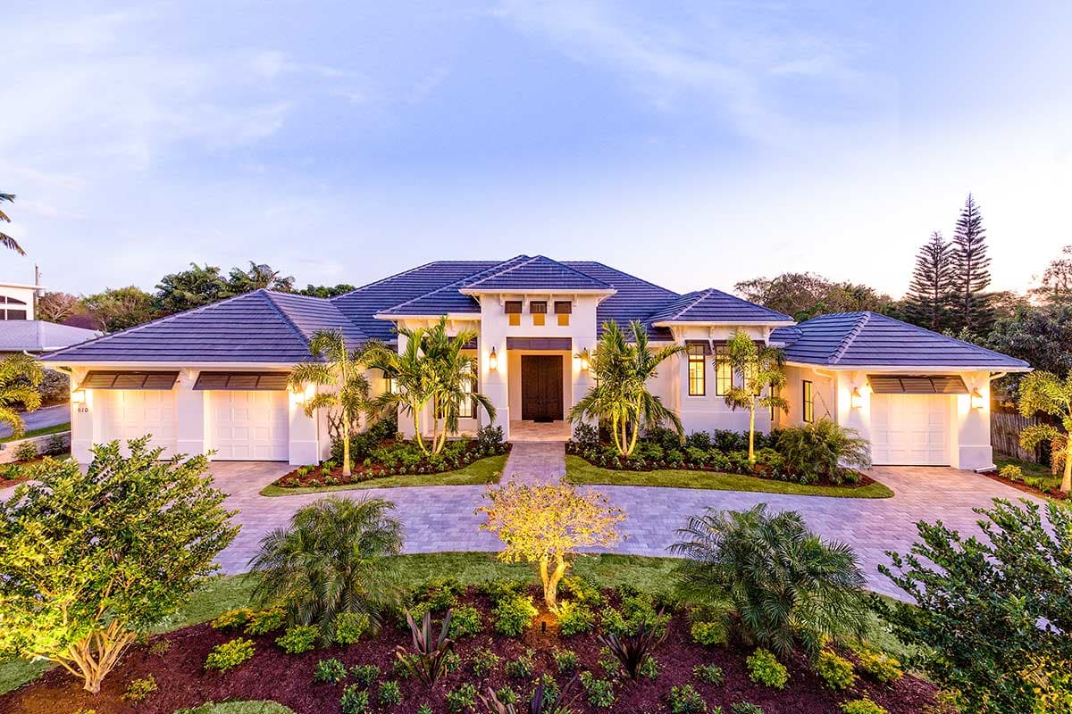 House plan exterior. One-story house with a tile roof, three-car garage, and portico-covered entry. Landscaping and driveway shown.