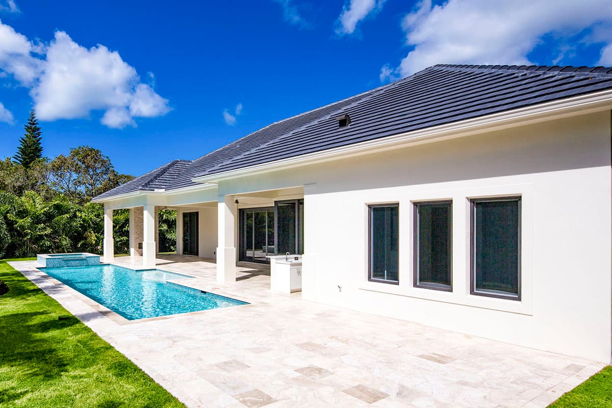 House plan exterior: Modern style, one-story residence with covered lanai, patio, pool, and multiple large windows.