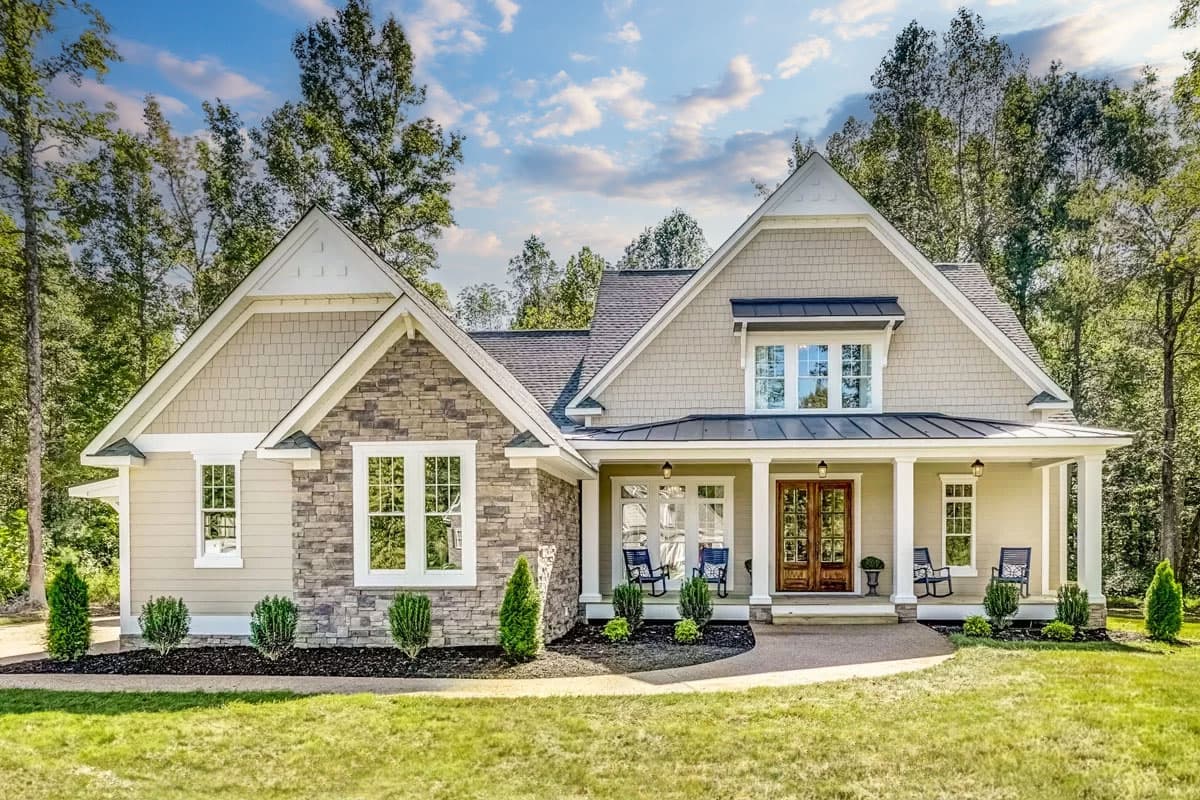 House plan exterior with Craftsman style. Features include gables, a covered porch with columns, and a stone facade. Two-story design.