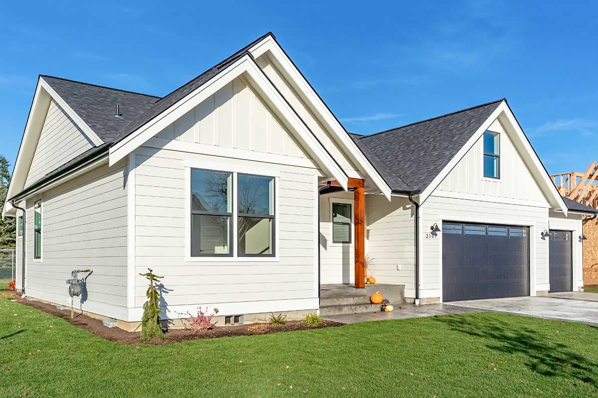 Modern Farmhouse style house plan exterior with a covered entry, prominent gables, and a two-car garage.