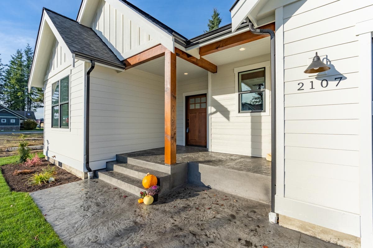 Modern Farmhouse exterior with board and batten siding, gable roof, exposed beams, and covered entry.