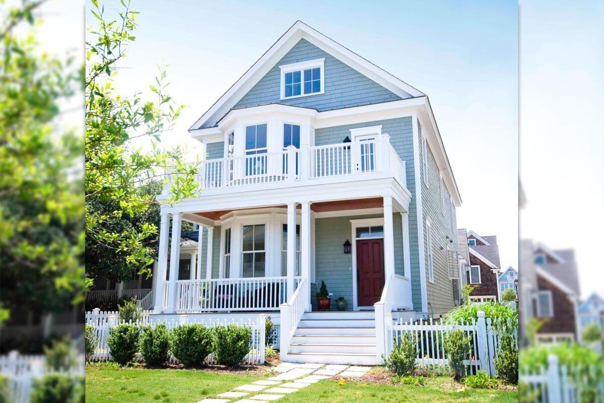 House plan exterior. Two-story home with a wrap-around porch, upper-level balcony, and gabled roof with dormer window.
