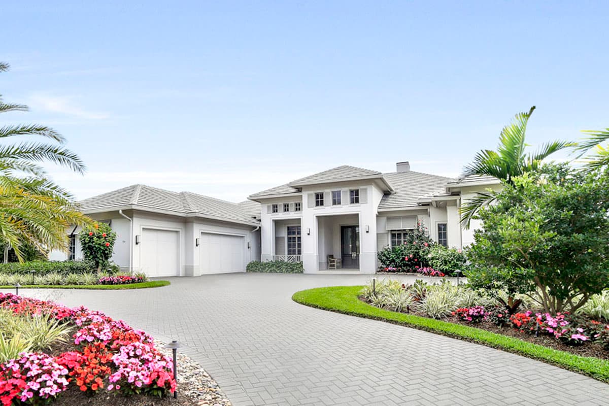House plan exterior with two stories. Features include a front-entry portico, multiple gables, and a three-car garage.