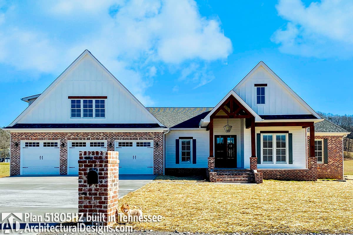 House plan exterior: Modern Farmhouse style, one story, with a three-car garage, gabled dormers, and covered entry with exposed beams.
